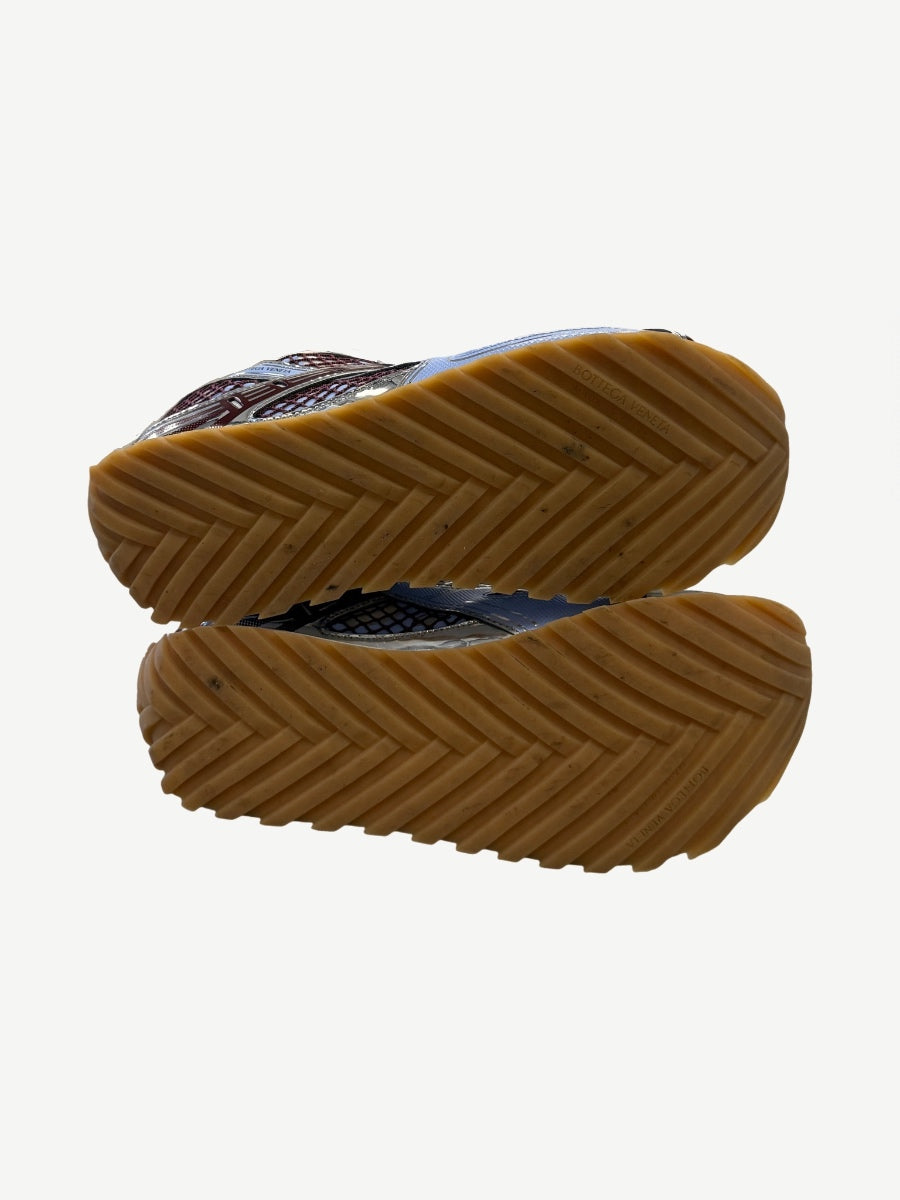Bottega Veneta Orbit sneakers outsole view showing chevron gum rubber tread and brand stamp.