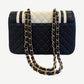 Back of Chanel Cosmopolite bicolor lambskin flap bag showing diamond quilted black leather and woven chain strap