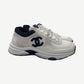 Chanel white suede and mesh low top trainer side view with large black CC monogram and black heel tab