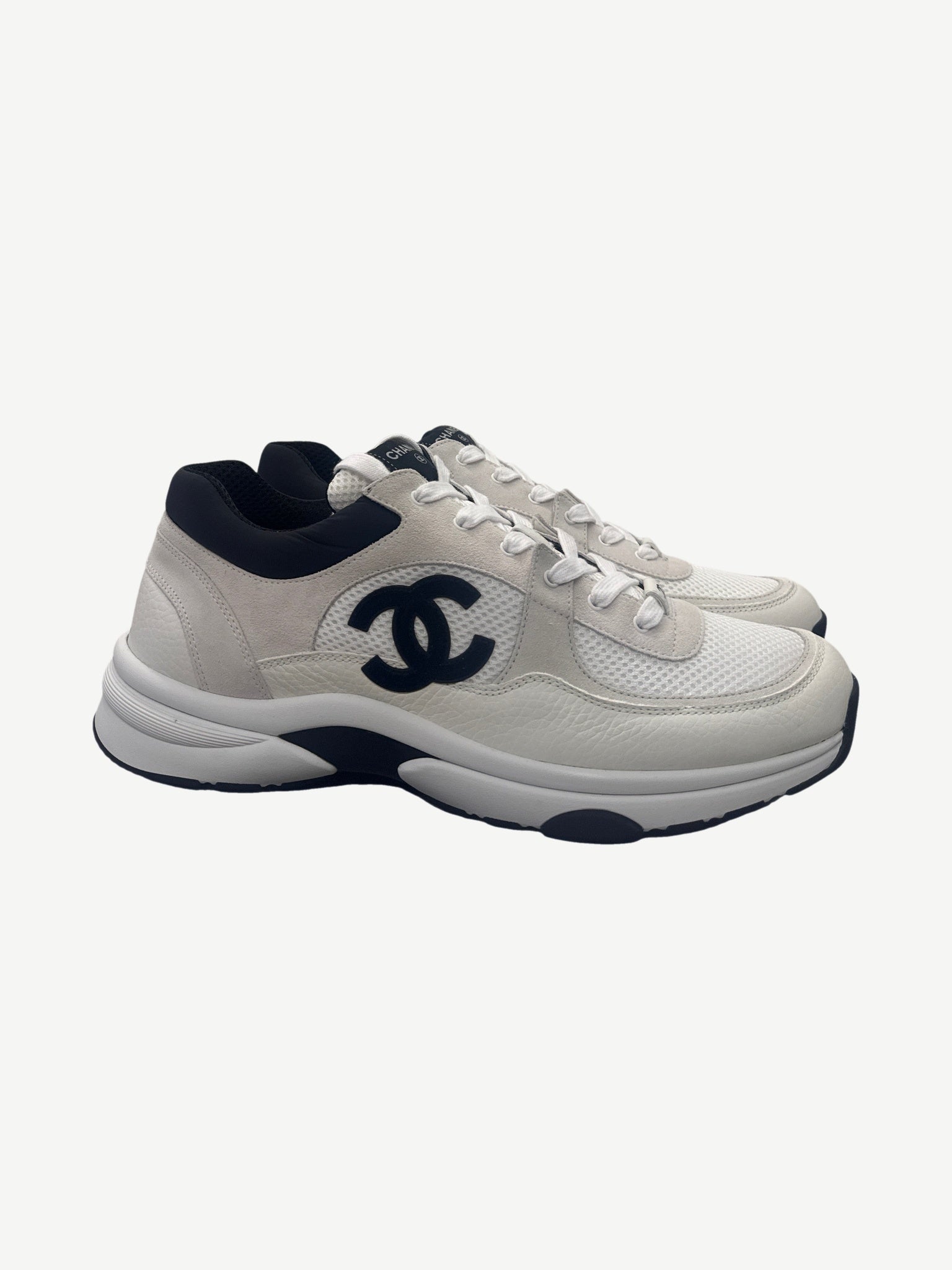 Chanel white suede and mesh low top trainer side view with large black CC monogram and black heel tab