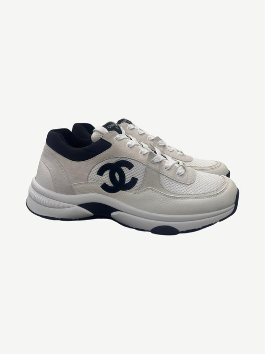 Chanel white suede and mesh low top trainer side view with large black CC monogram and black heel tab