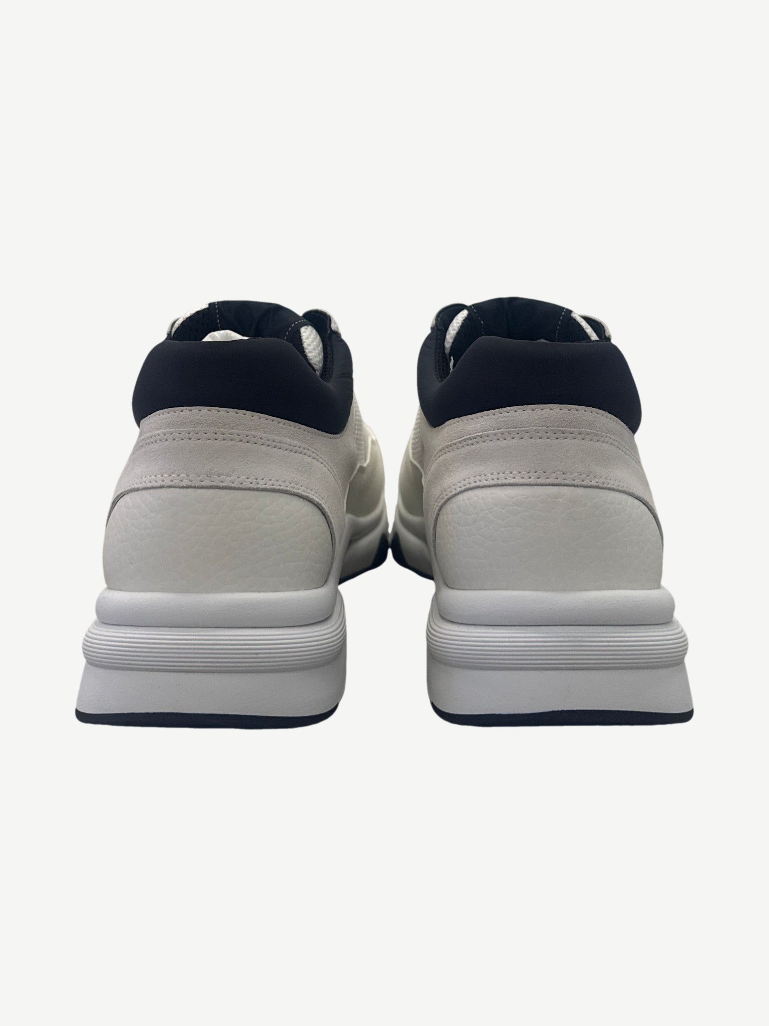 Chanel low top trainer back heel view showing black neoprene collar and white tumbled leather panel