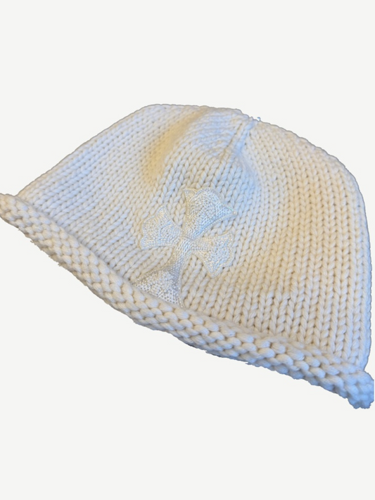 Chrome Hearts cream knit beanie angled view with thick rolled brim and beaded ivory cross applique on side.