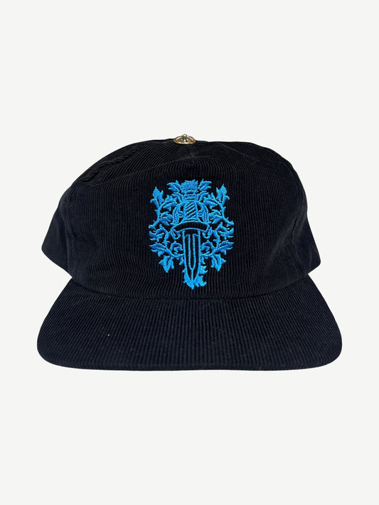 Chrome Hearts black corduroy dad hat with embroidered blue floral dagger crest on the front panel.