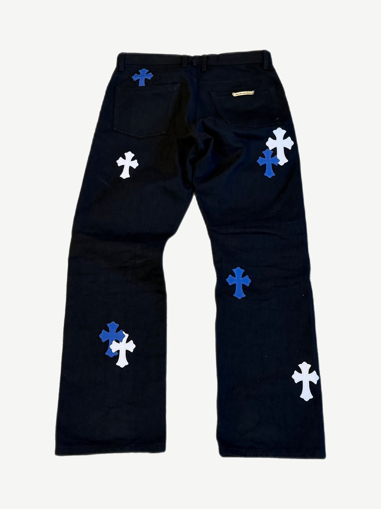 Chrome Hearts black cross patch jeans back, blue and white leather crosses across pockets and down both legs.