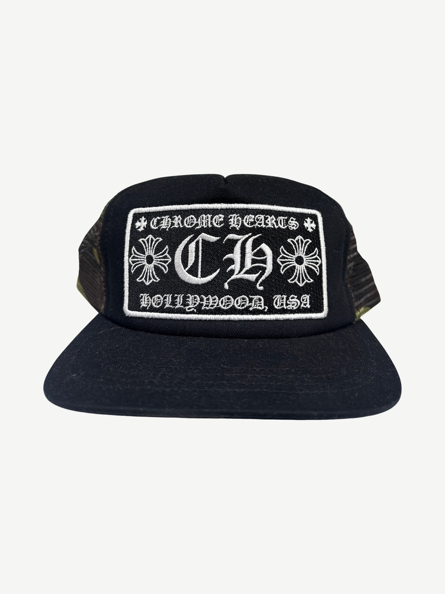 Chrome Hearts Hollywood trucker hat with black camo crown, white mesh back and embroidered CH front patch.