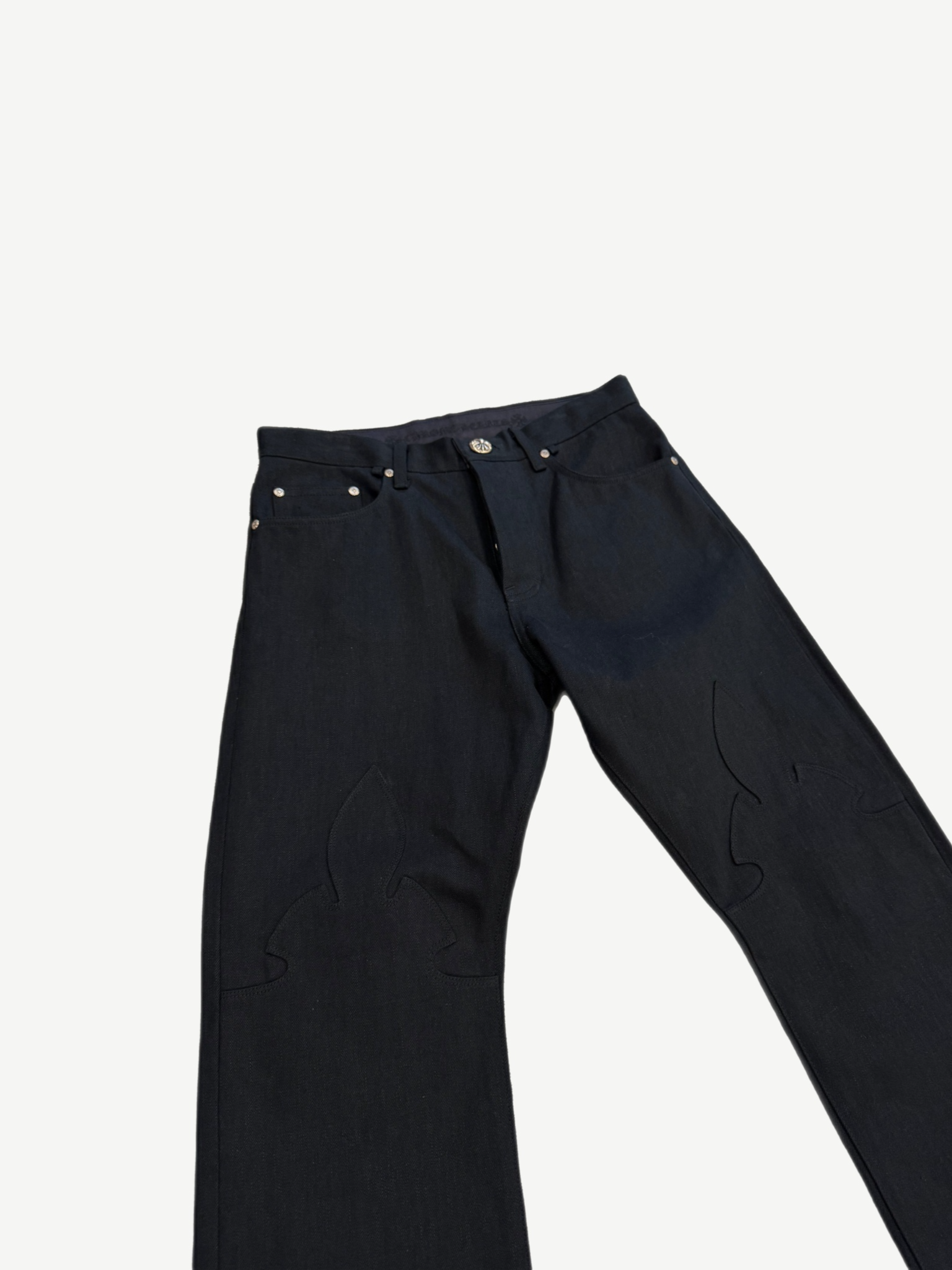 Chrome Hearts black Fleur jeans cropped top-half view showing button fly closure and leather cross knee patches