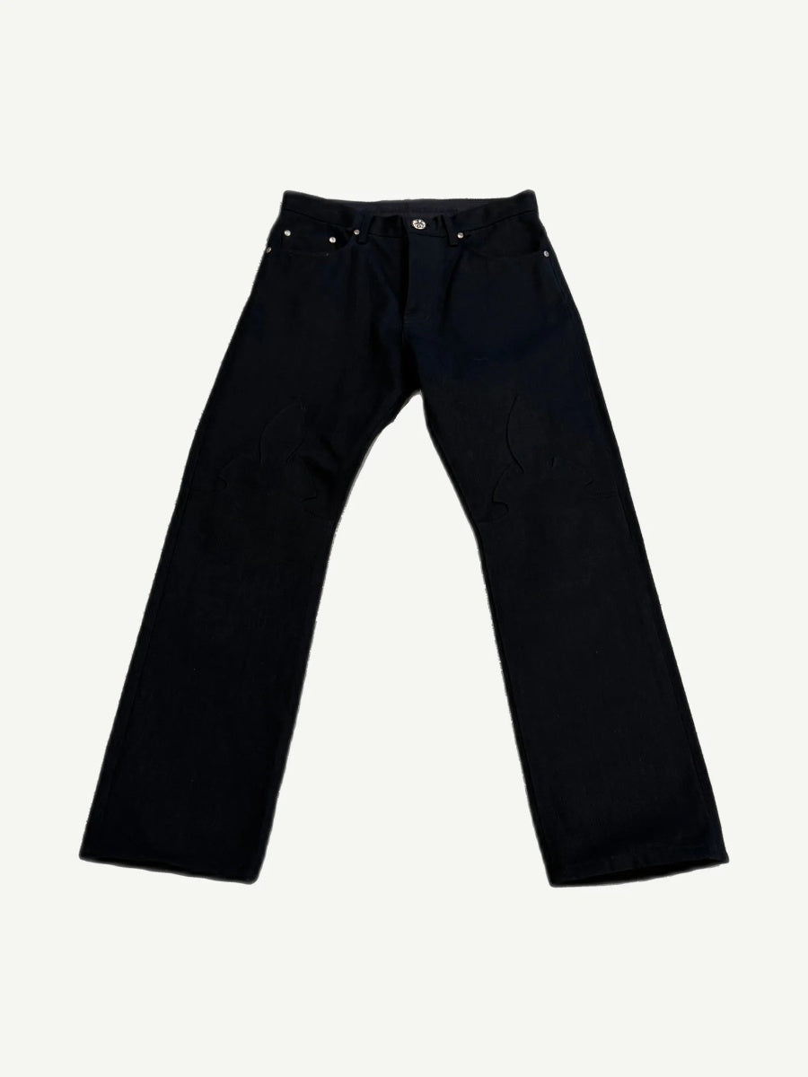 Chrome Hearts black Fleur knee jeans front view with leather cross patch knee appliques and silver hardware