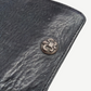 Chrome Hearts black leather wallet close up of sterling silver fleur de lis snap hardware on grained leather
