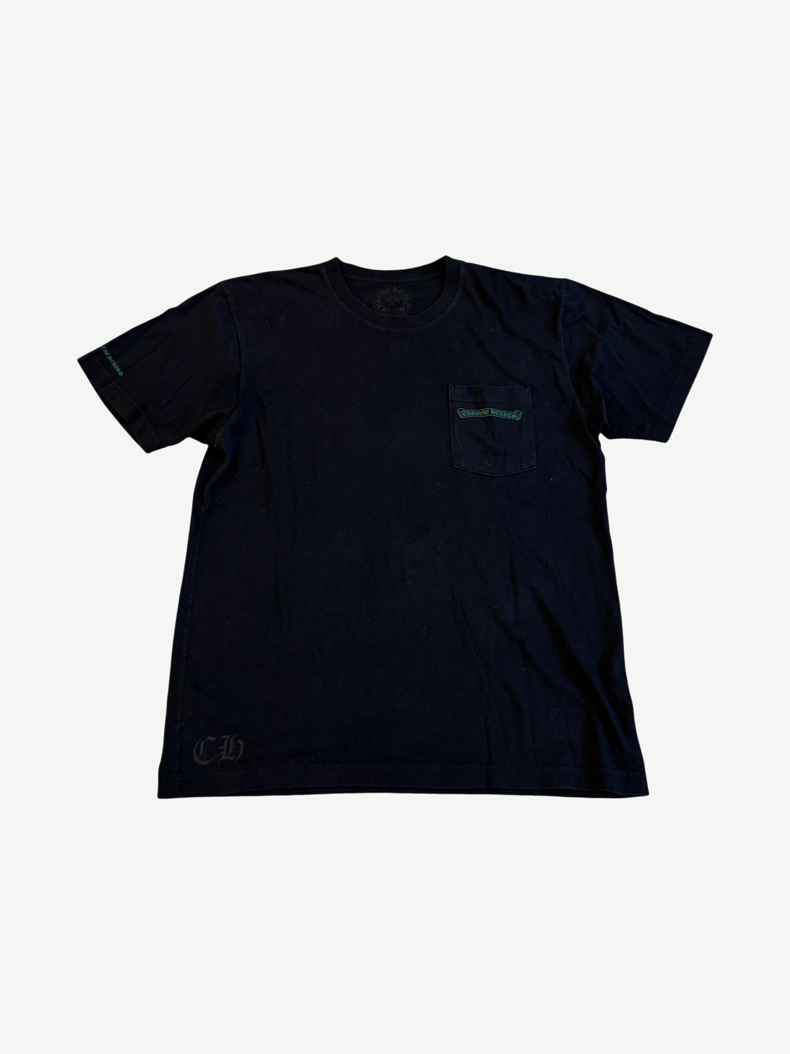 Chrome Hearts black pocket tee with green Cemetery Cross logo print on chest pocket and sleeve.