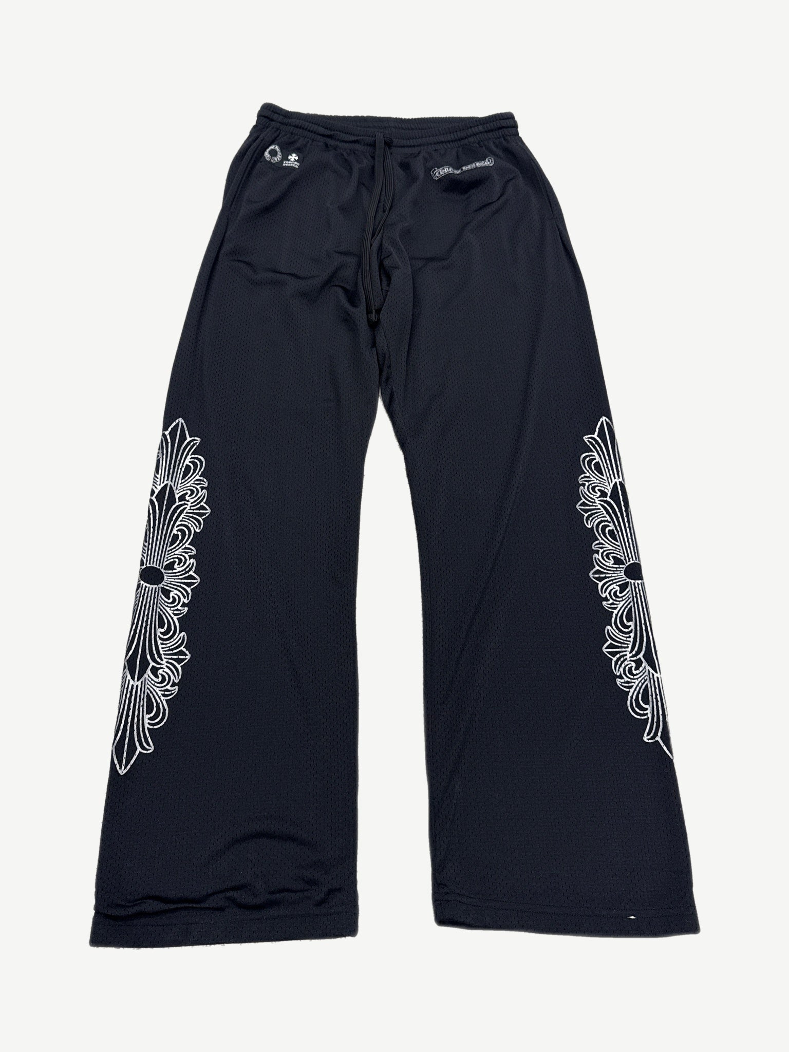 Chrome Hearts black mesh warm up sweatpants with white floral cross dagger embroidery on both legs, front view