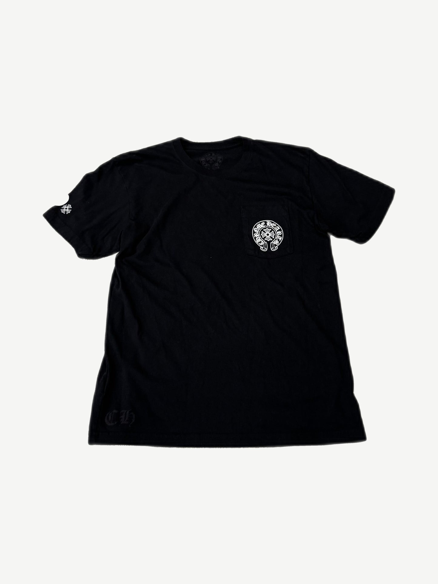 Chrome Hearts black tee front with white horseshoe pocket print and CH old English hem text.