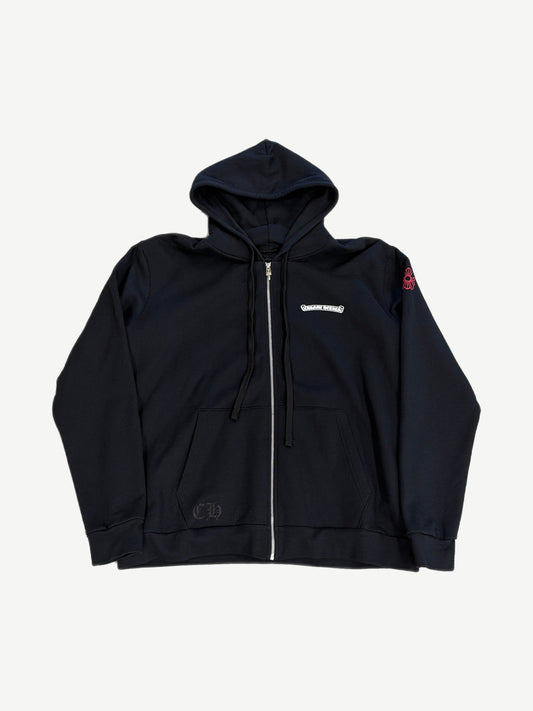 Chrome Hearts black zip hoodie front with small chest scroll logo and red cross patch on right sleeve