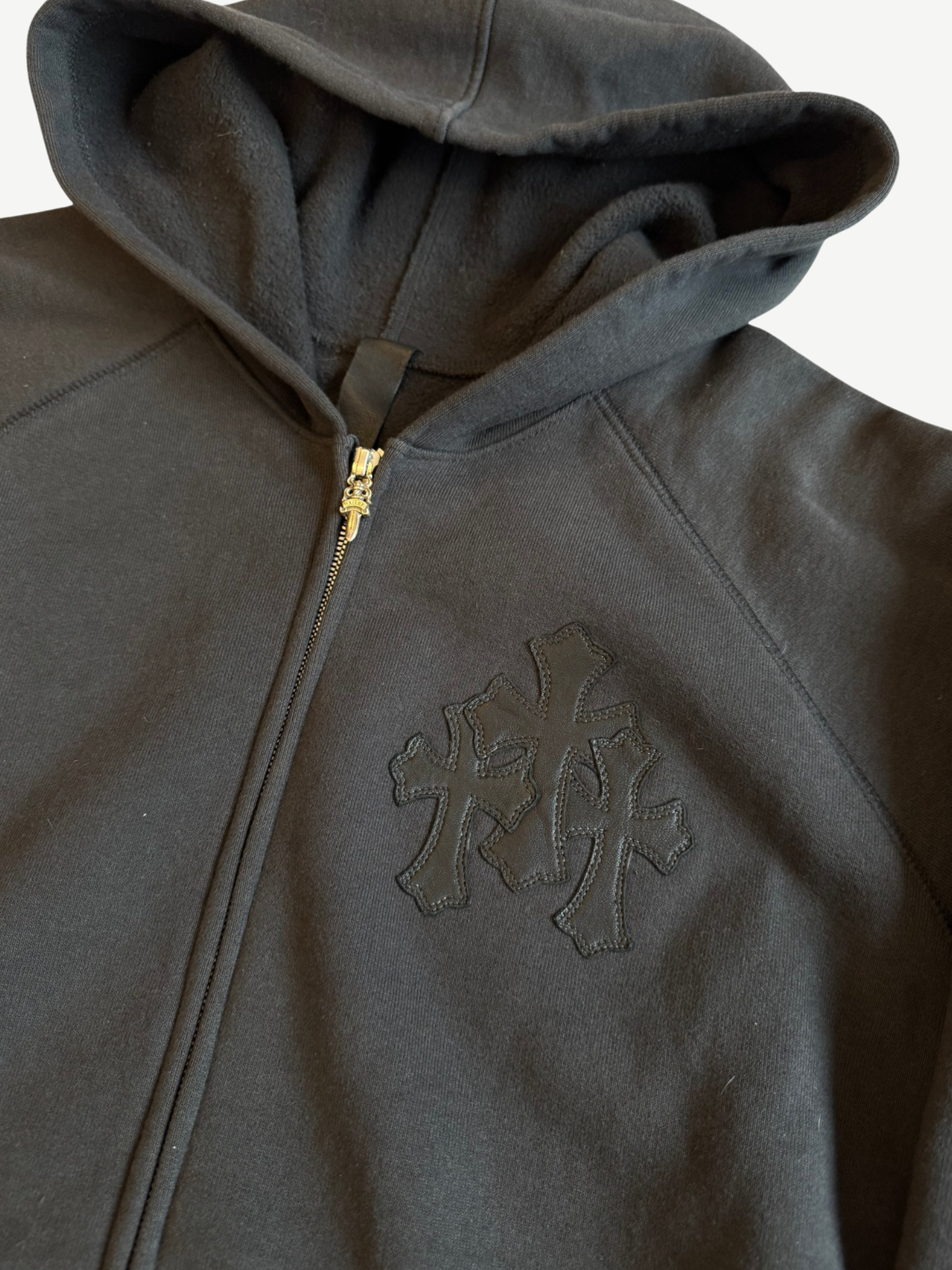Chrome Hearts Paper Jam zip up close up of tonal black triple cross applique and gold zipper hardware.