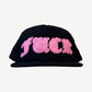 Chrome Hearts black mesh trucker hat with pink Old English Fuck leather patch across front panel.