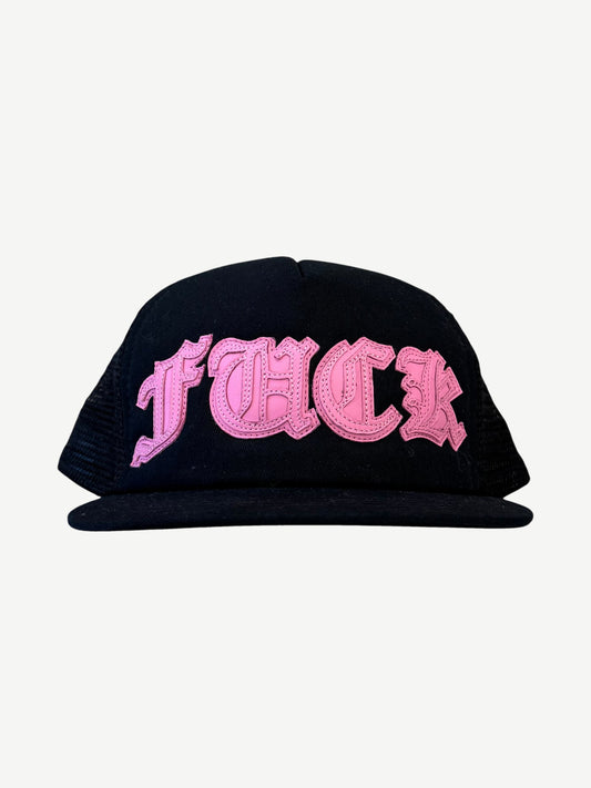 Chrome Hearts black mesh trucker hat with pink Old English Fuck leather patch across front panel.