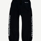 Chrome Hearts black sweatpants front, white Old English scroll logo down both legs with drawstring waist.