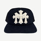 Chrome Hearts black trucker hat front with white pony hair triple cross patch and snapback closure detail.