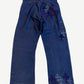Chrome Hearts blue French work pants back, clustered cross leather patches across right hip and lower leg.