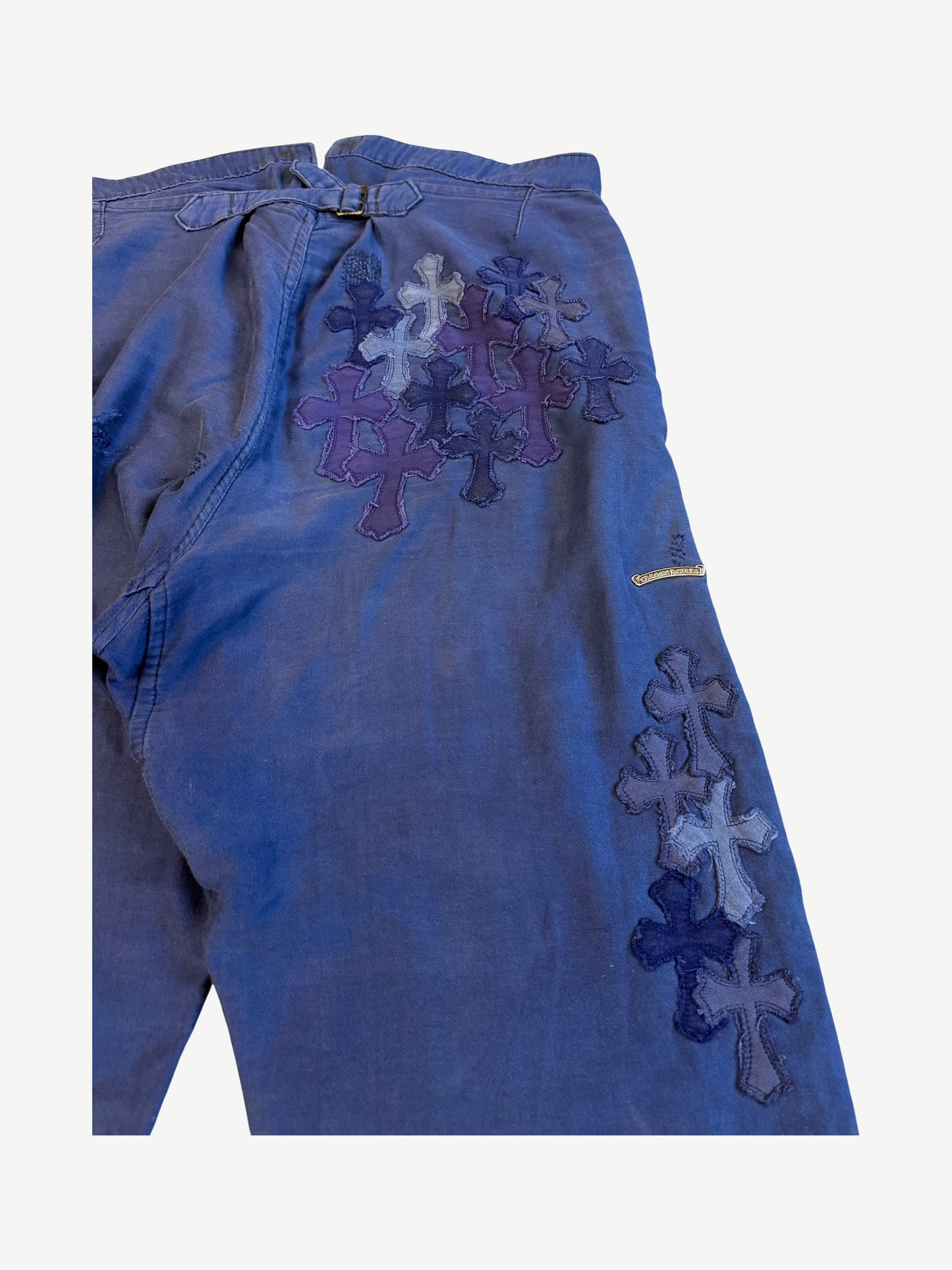 Chrome Hearts blue French work pants detail, dense layered cross leather patches in navy and purple tones.