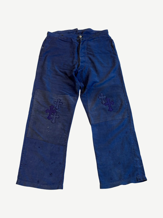 Chrome Hearts blue French work pants front with tonal purple and navy leather cross patches on both knees.