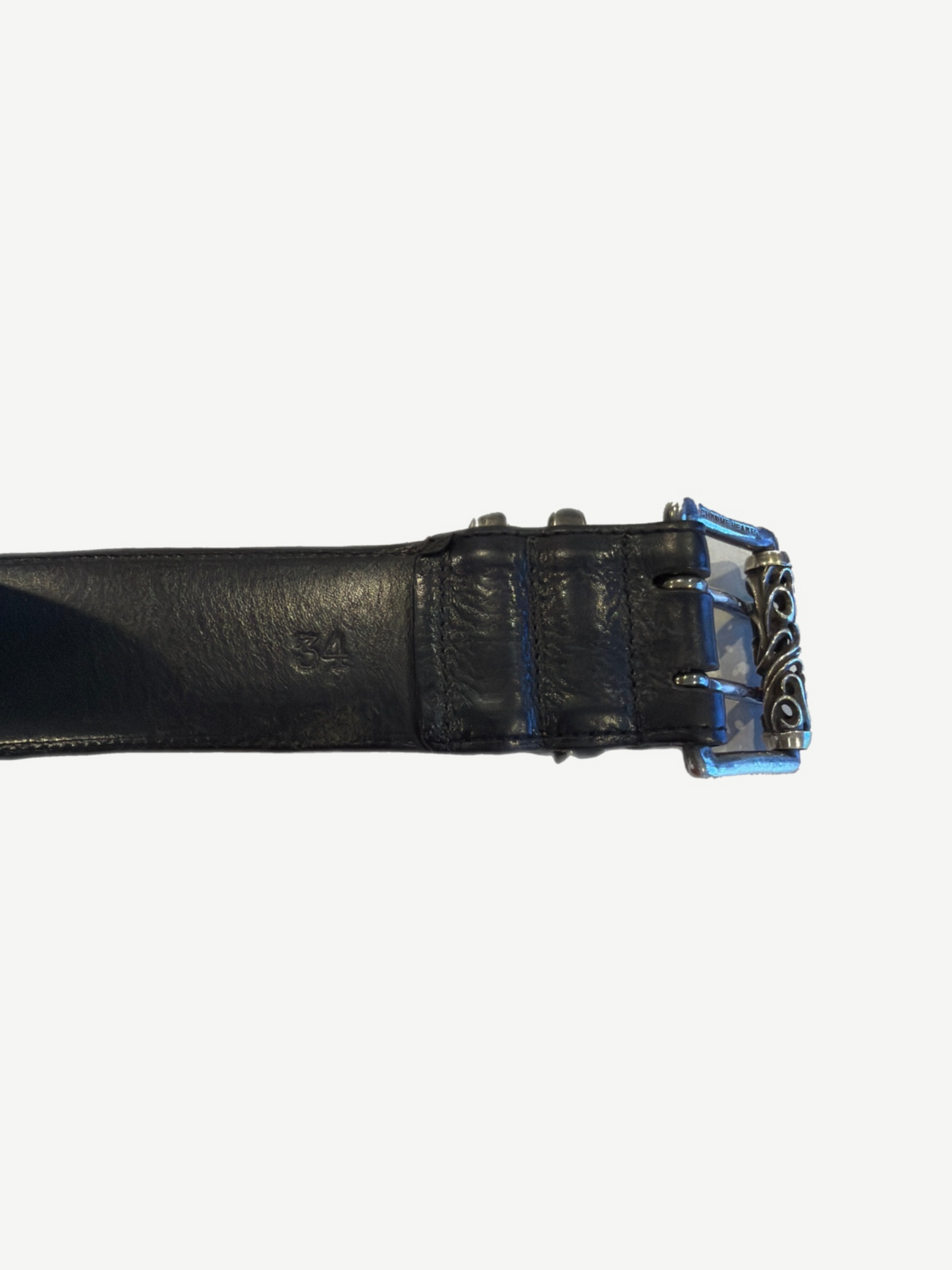 Chrome Hearts Celtic belt strap end close-up showing embossed CH stamp and black leather keeper loops