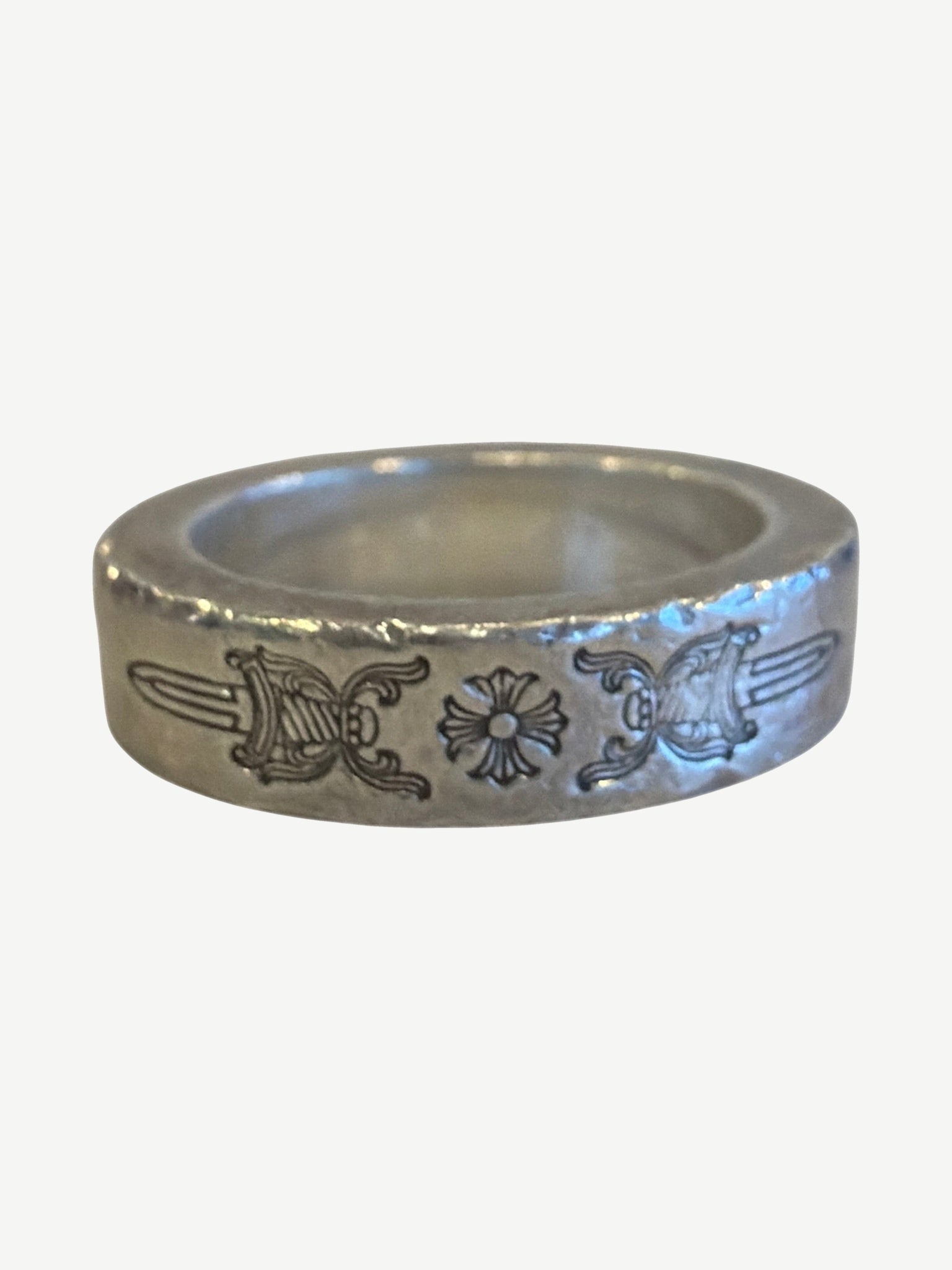 Chrome Hearts Dagger Spacer ring side view showing hand-engraved dagger flourishes and hammered silver edges.