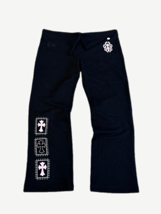 Chrome Hearts black sweatpants with three stacked white cross patches on left leg and CH waist logo, front view