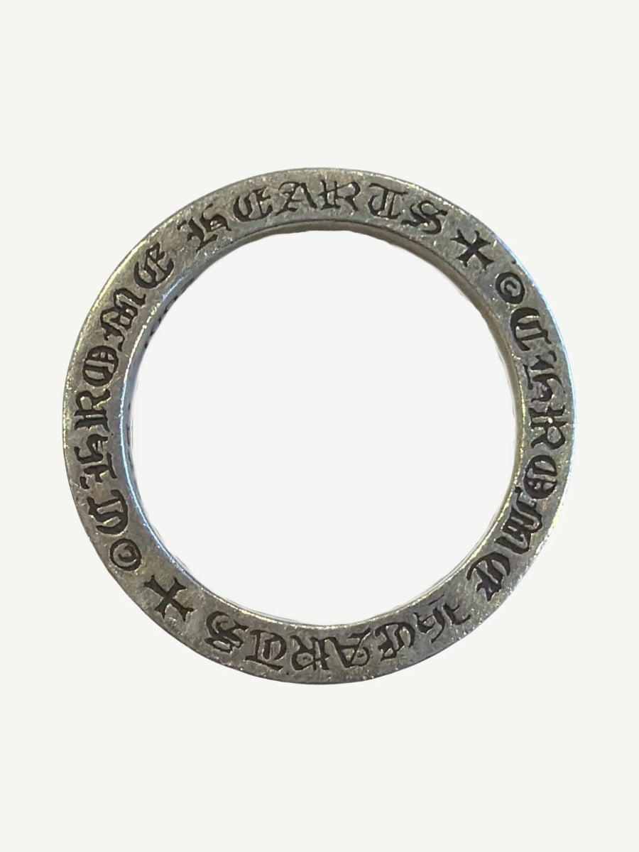 Top-down view of Chrome Hearts F You silver spacer ring showing Chrome Hearts engraved around inner band.