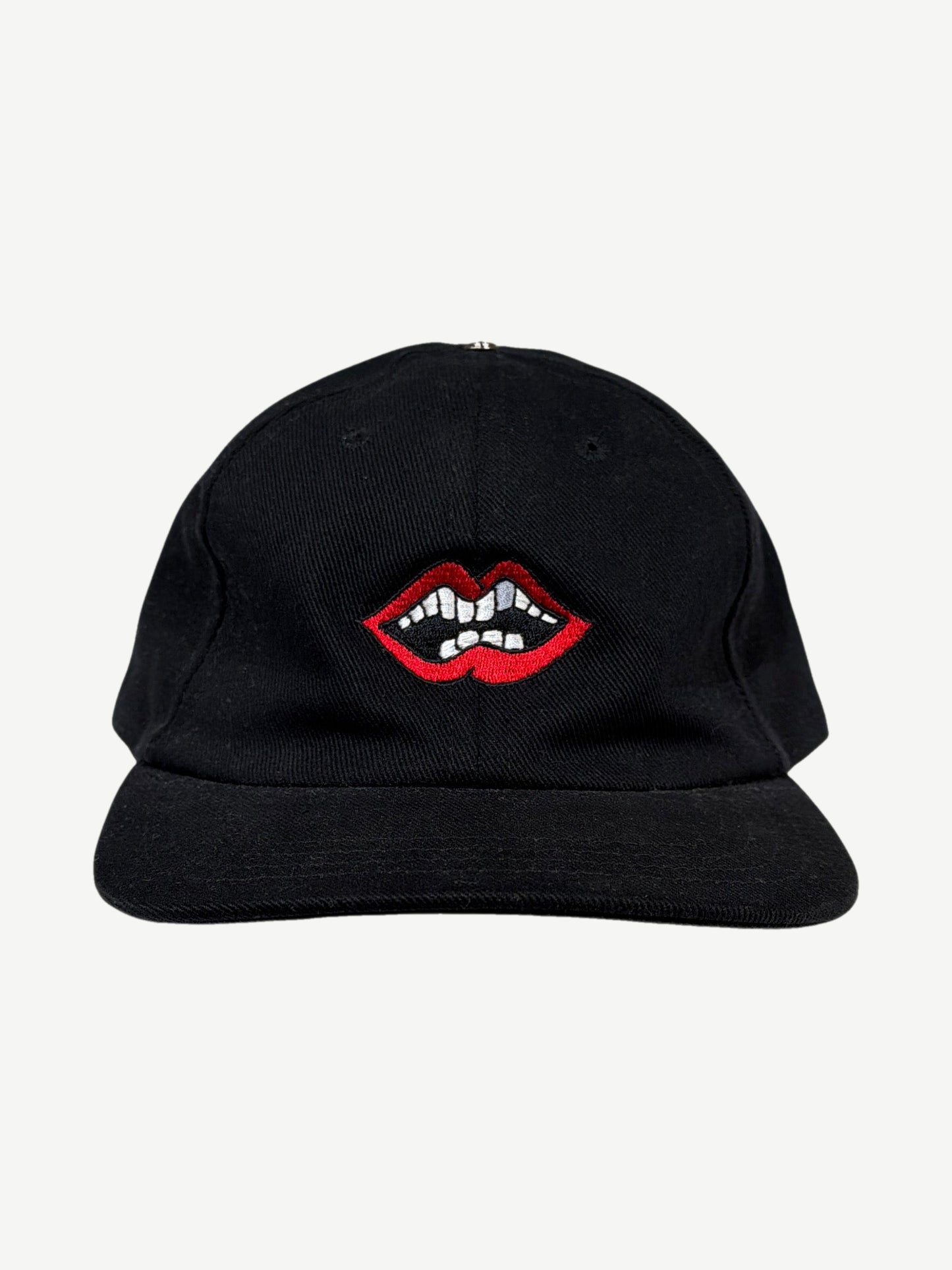 Chrome Hearts x Matty Boy black Chomper strapback cap with embroidered red lips and teeth graphic at front