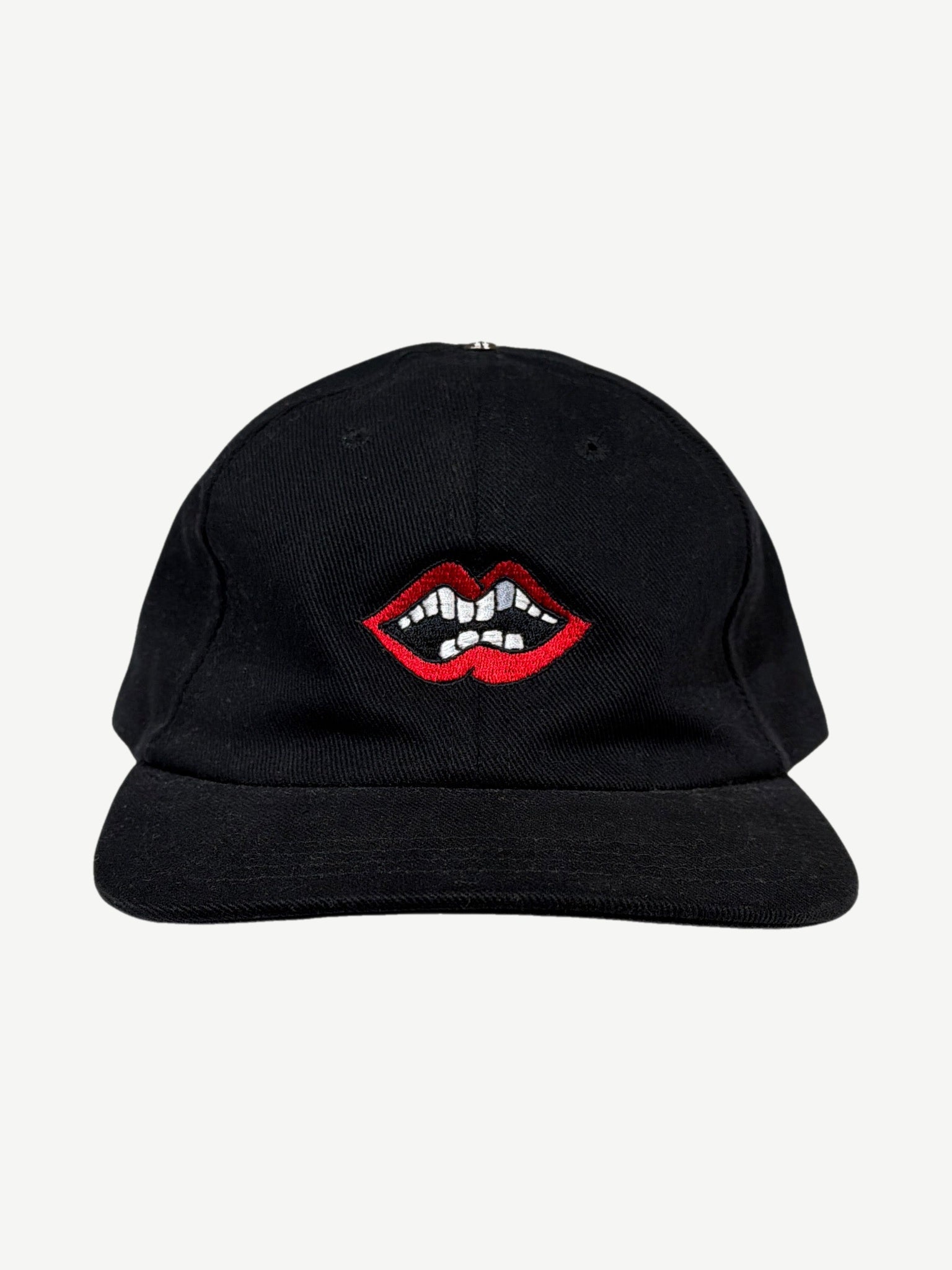 Chrome Hearts x Matty Boy black Chomper strapback cap with embroidered red lips and teeth graphic at front