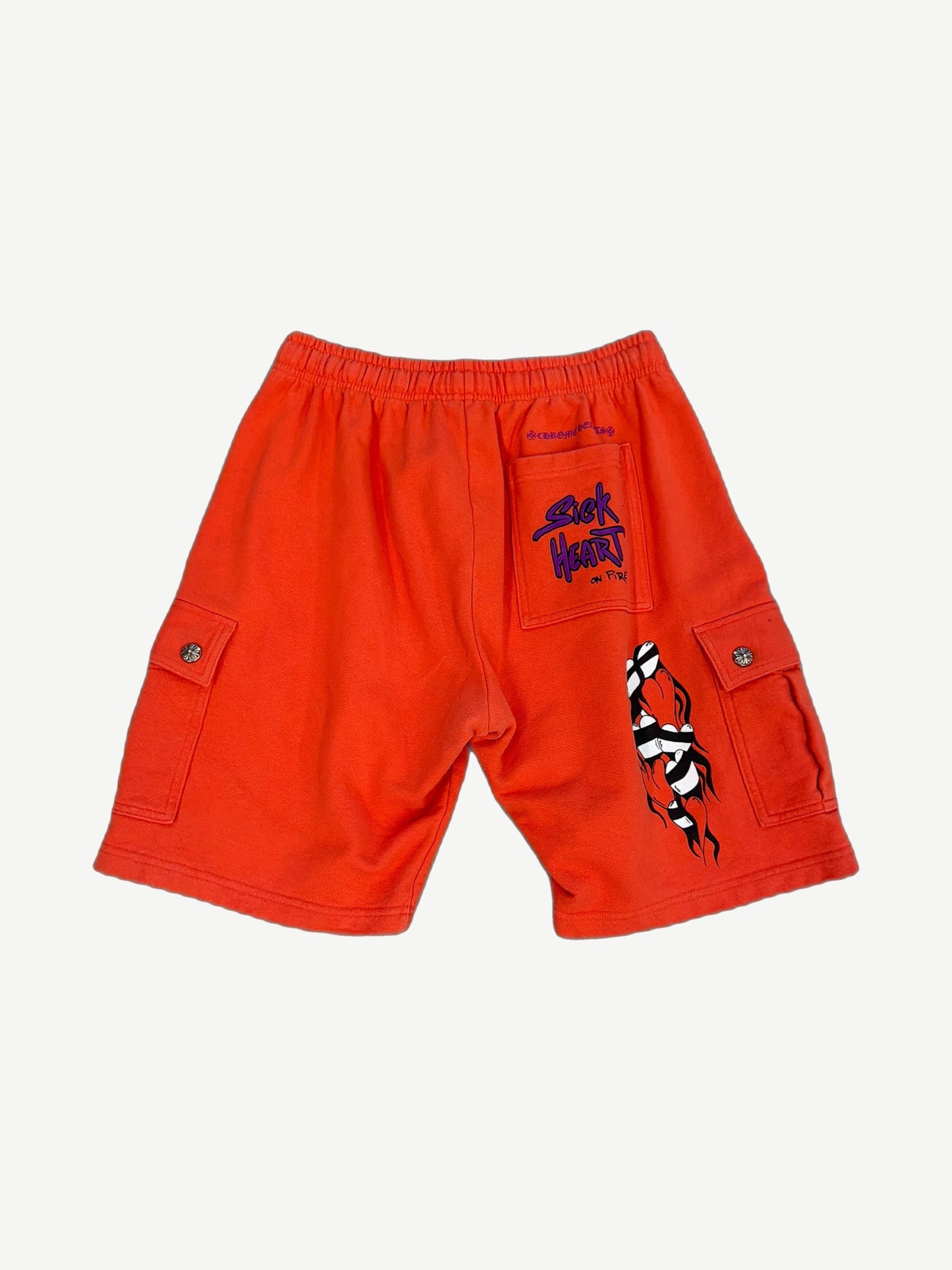 Chrome Hearts orange Matty Boy cargo shorts back showing Sick Heart On Fire pocket and flame leg graphic.