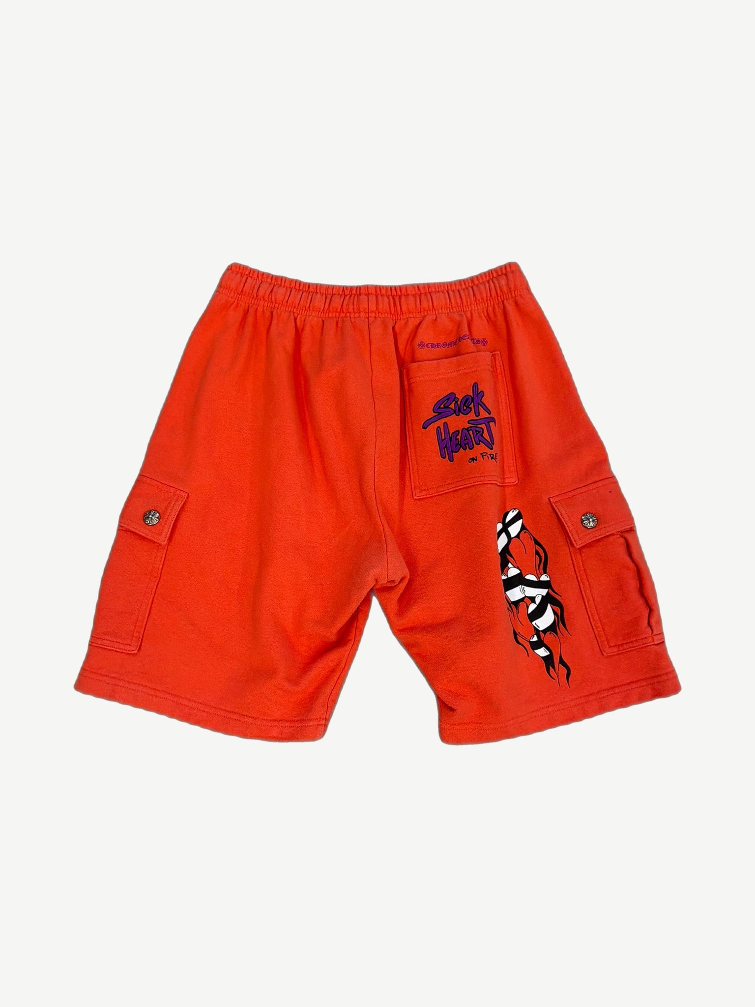 Chrome Hearts orange Matty Boy cargo shorts back showing Sick Heart On Fire pocket and flame leg graphic.