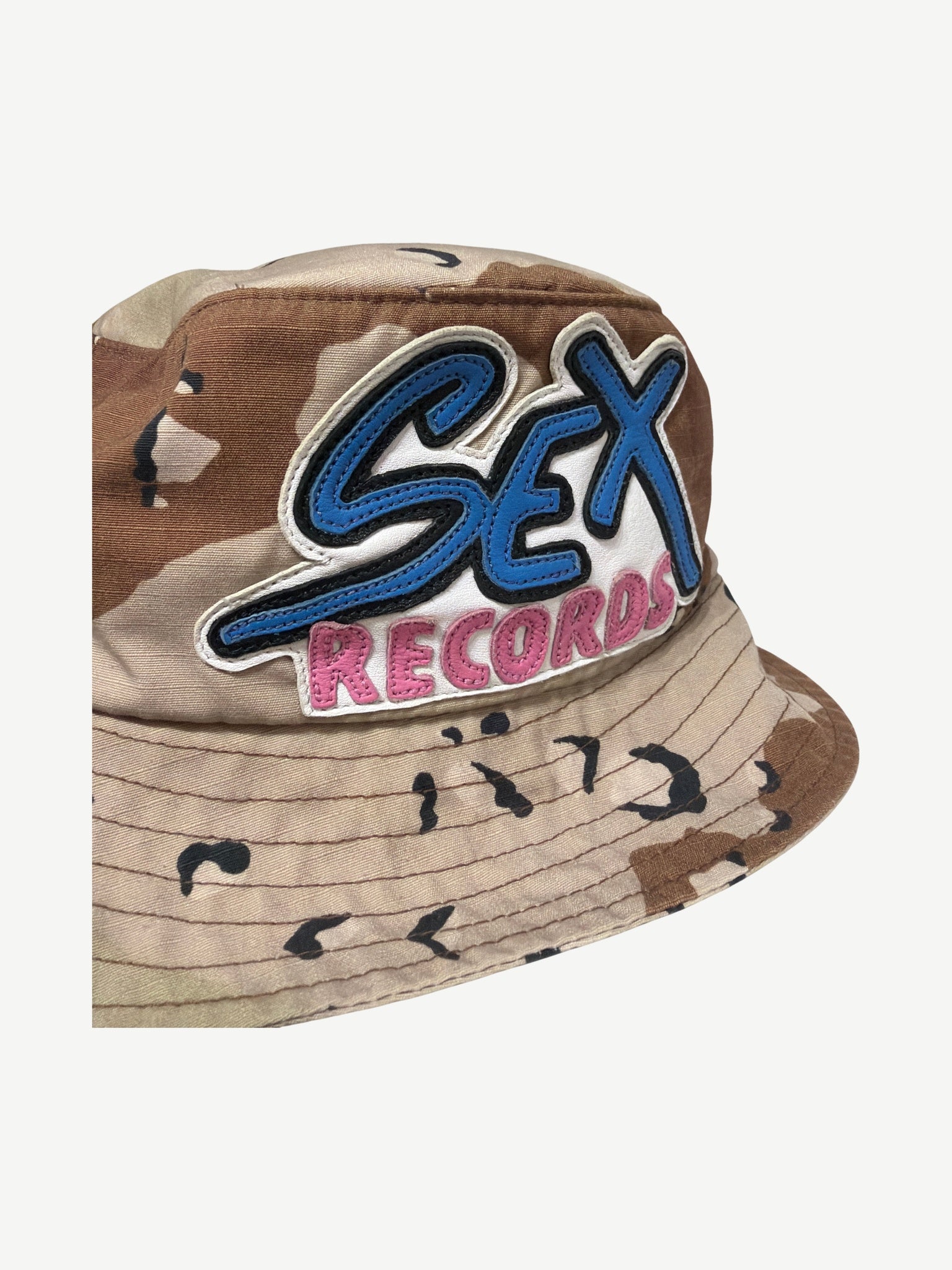 Chrome Hearts Sex Records camo bucket hat angled close up of leather patch stitching and camo ripstop