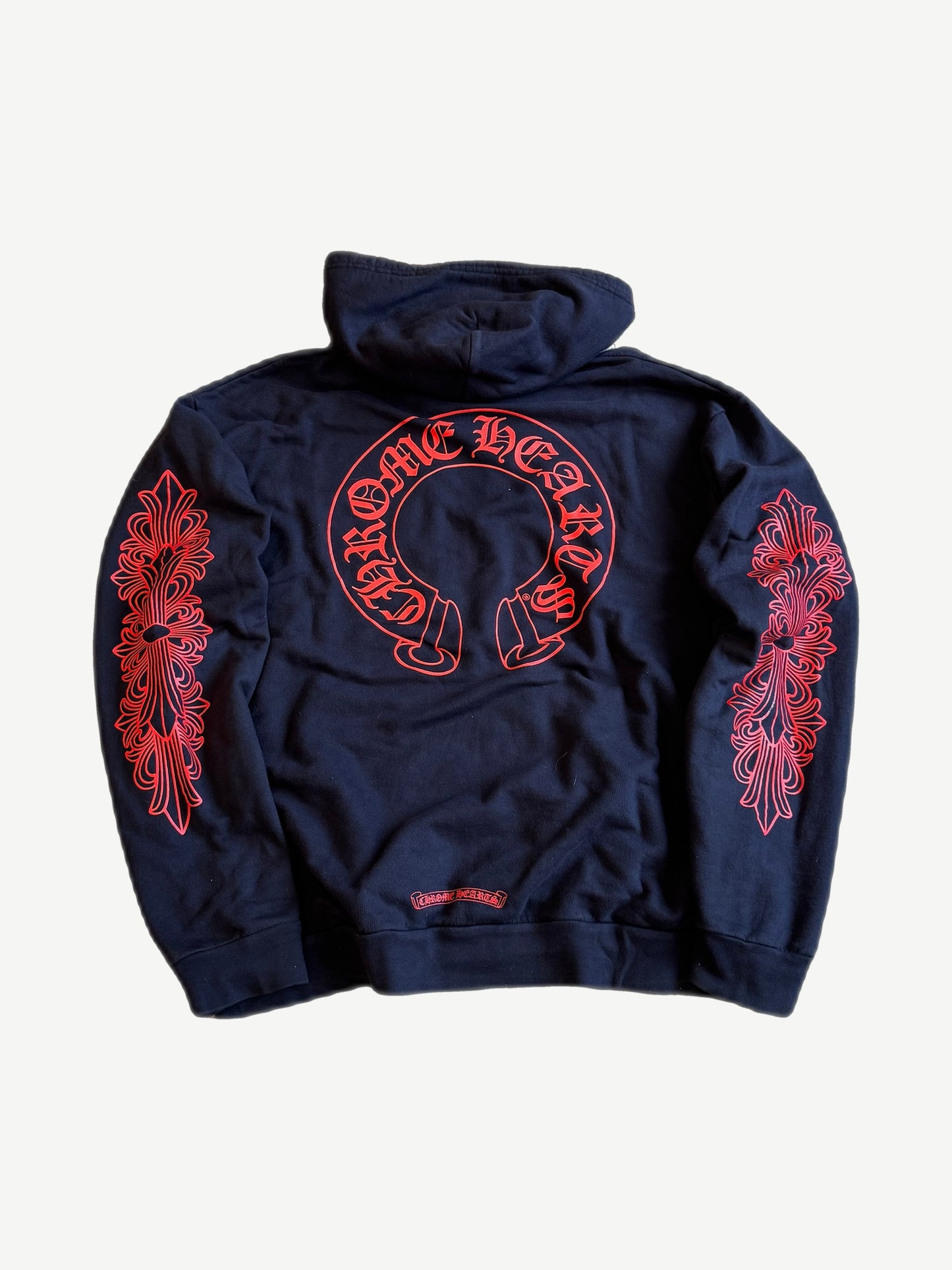 Chrome Hearts navy hoodie back with large red horseshoe logo and red floral cross prints down both sleeves