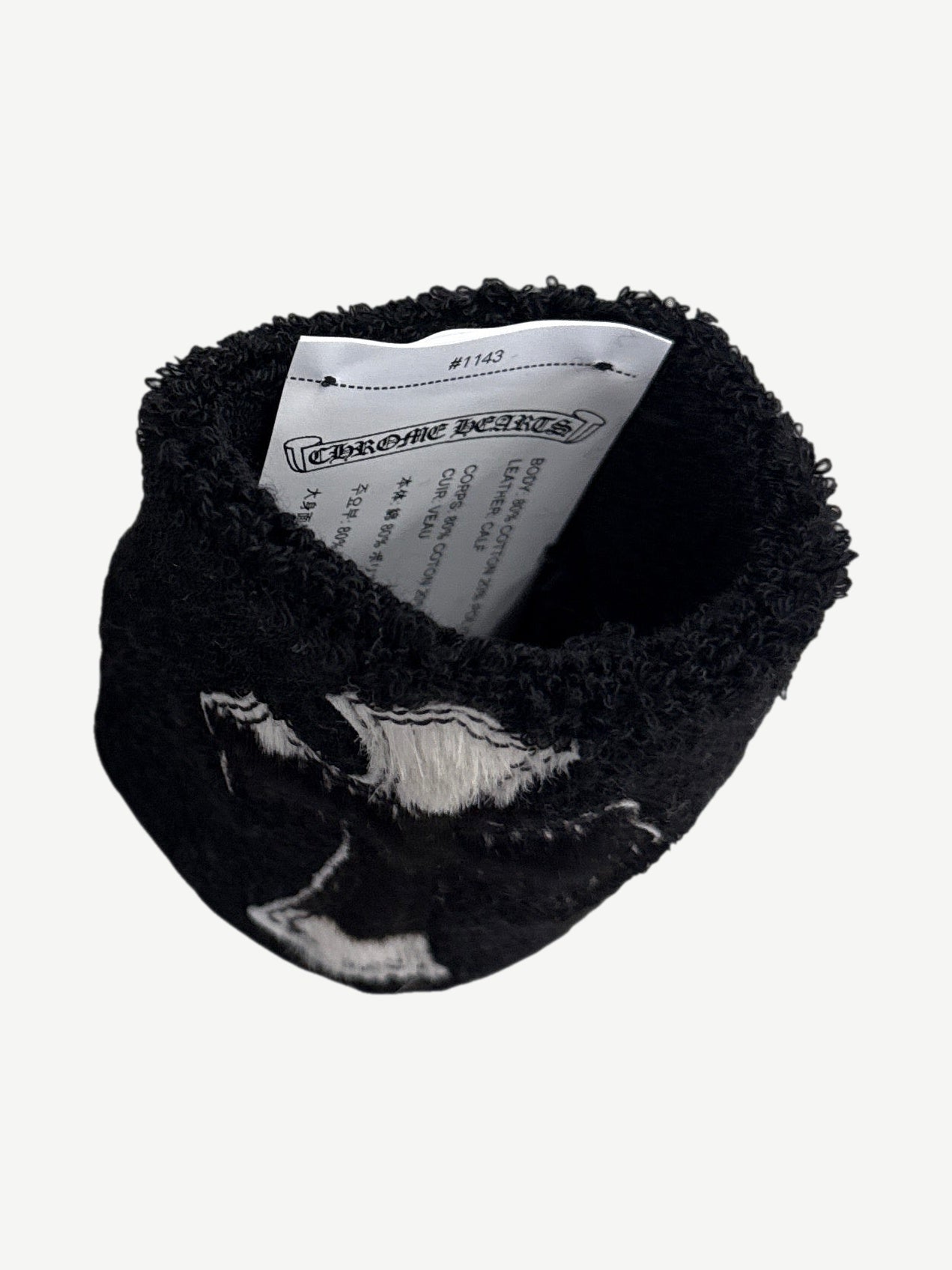 Chrome Hearts black sweatband detail close up of cowhide cross patch with white outline embroidery
