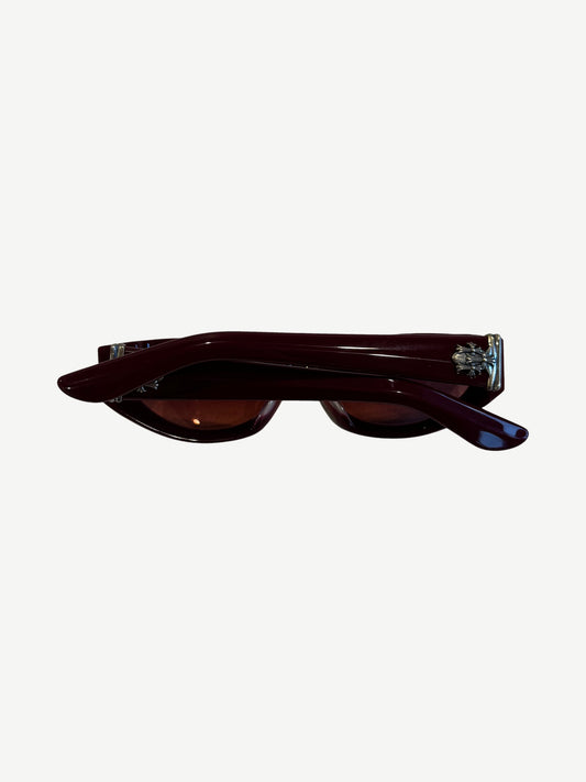 Chrome Hearts red Edenbox sunglasses side profile showing silver cross hardware at temples and burgundy arms.