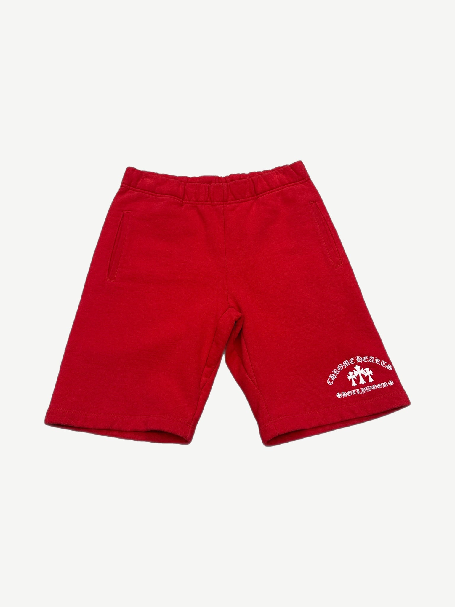 Chrome Hearts red sweat shorts with white embroidered cemetery cross on the left leg and elastic drawcord waist.