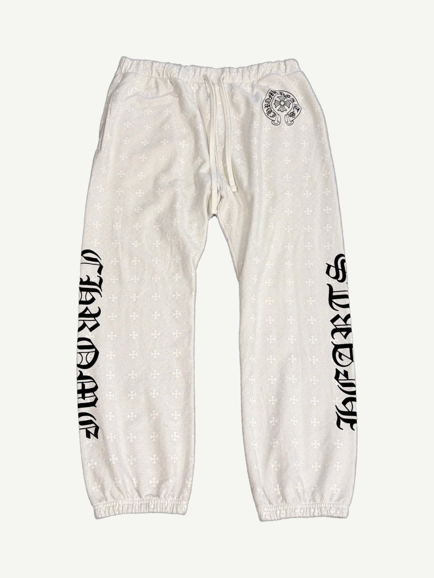 Chrome Hearts cream sweatpants front with allover tonal cross monogram and black gothic Chrome Hearts legs.