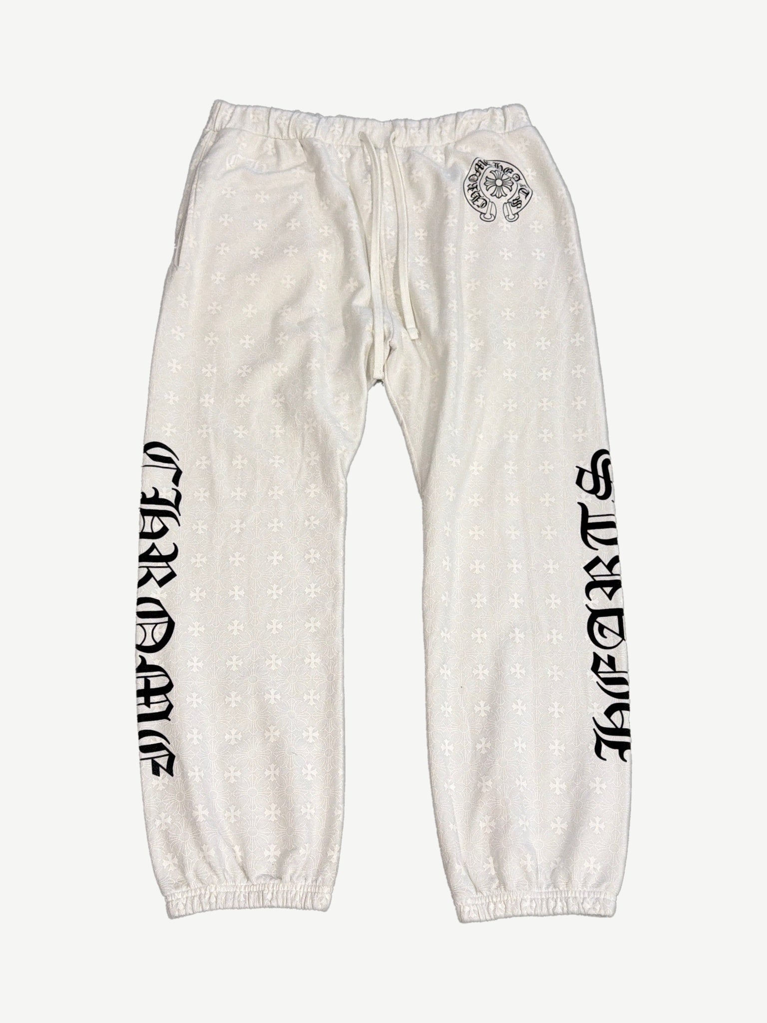 Chrome Hearts cream sweatpants front with allover tonal cross monogram and black gothic Chrome Hearts legs.