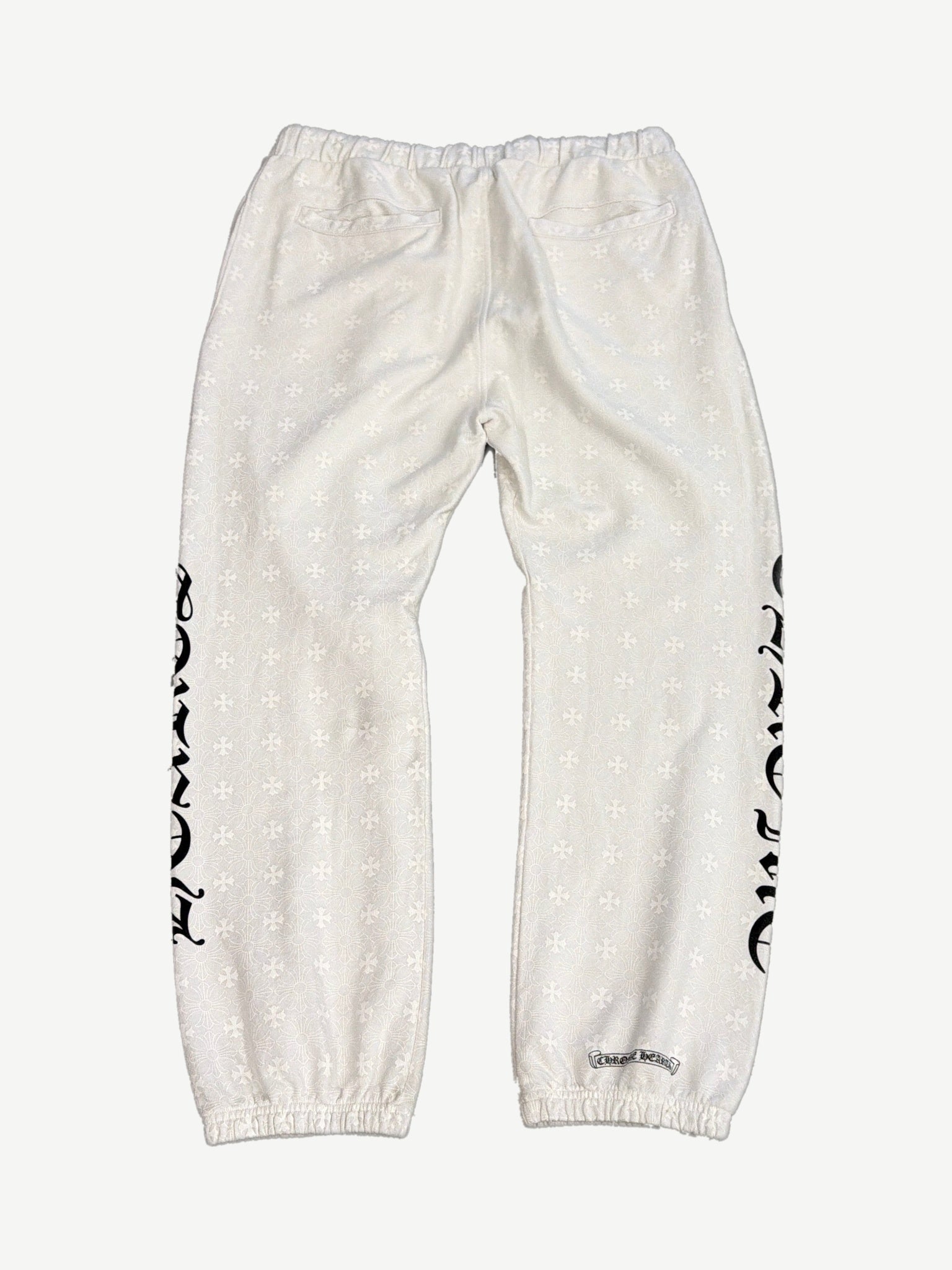 Chrome Hearts white monogram sweatpants back view with allover cross print and gothic CH leg lettering.