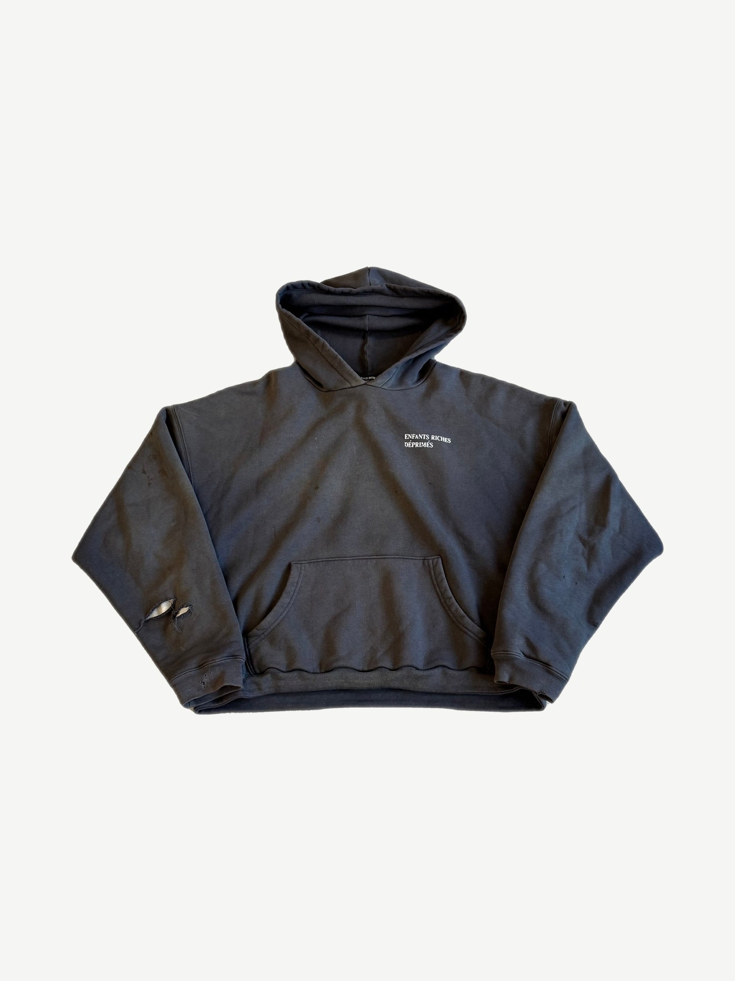 Enfants Riches Deprimes faded black distressed hoodie front with chest logo and ripped sleeve.