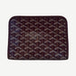 Goyard maroon Jouvence PM pouch side angle showing chevron Y print, leather trim and pull tab.