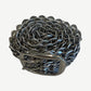 Greedy Unit bottle cap belt coiled showing rosette pattern of interlocking silver bottle cap rings