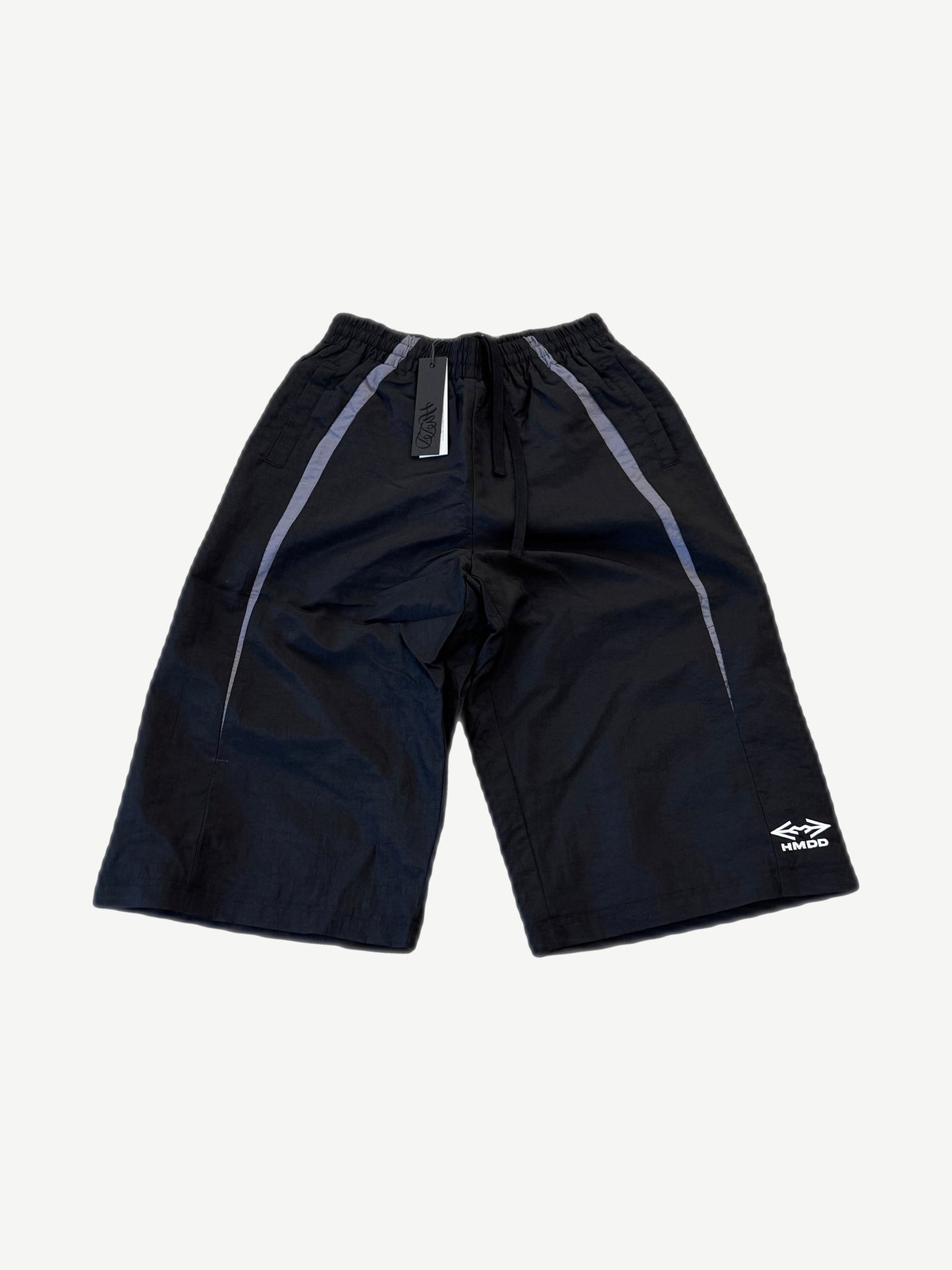 HMDD Juggernaut black nylon shorts front with grey side stripes, drawcord waist and HMDD logo at hem.