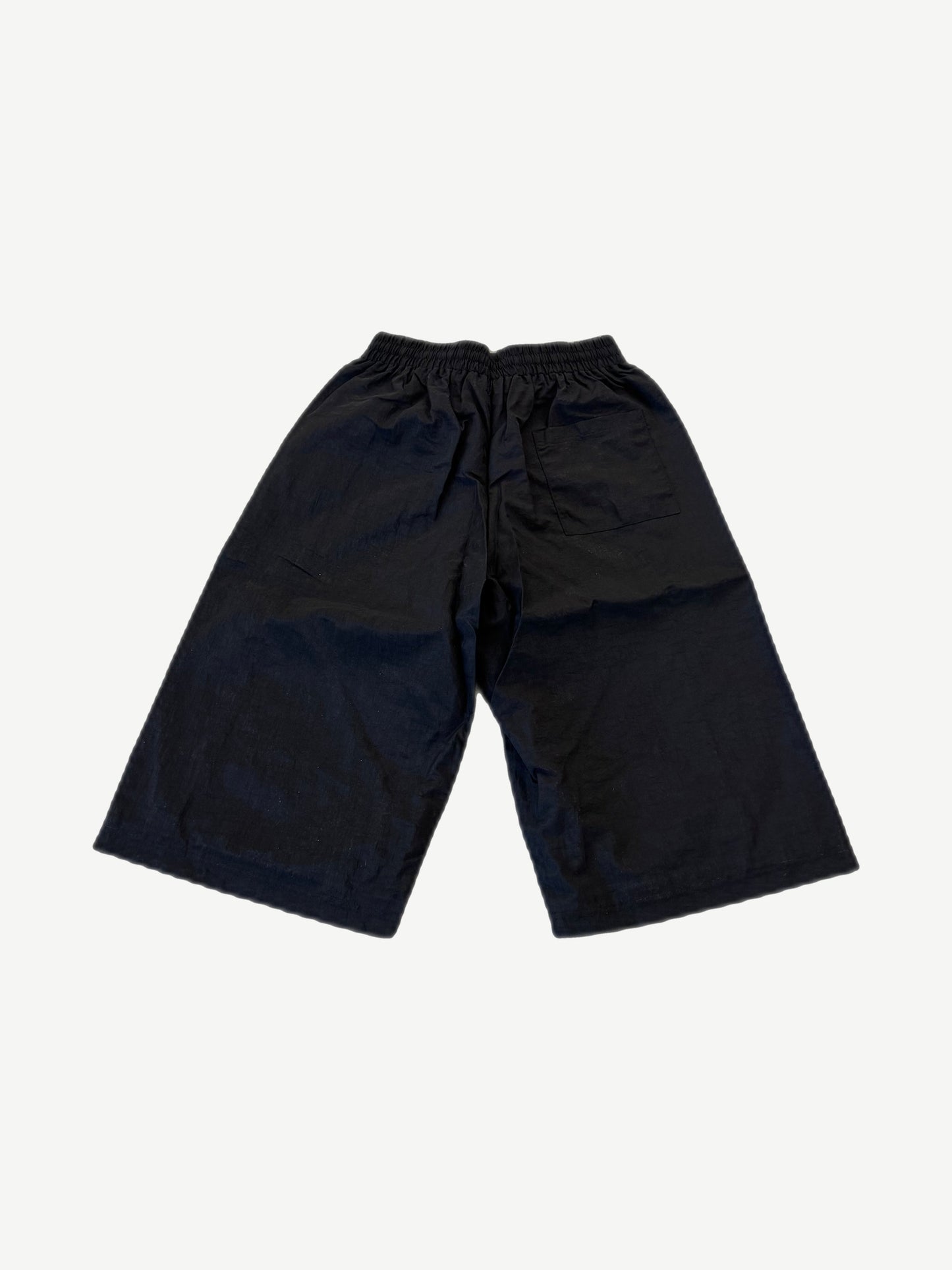 HMDD Juggernaut black nylon shorts back view with elastic waistband and single rear patch pocket.