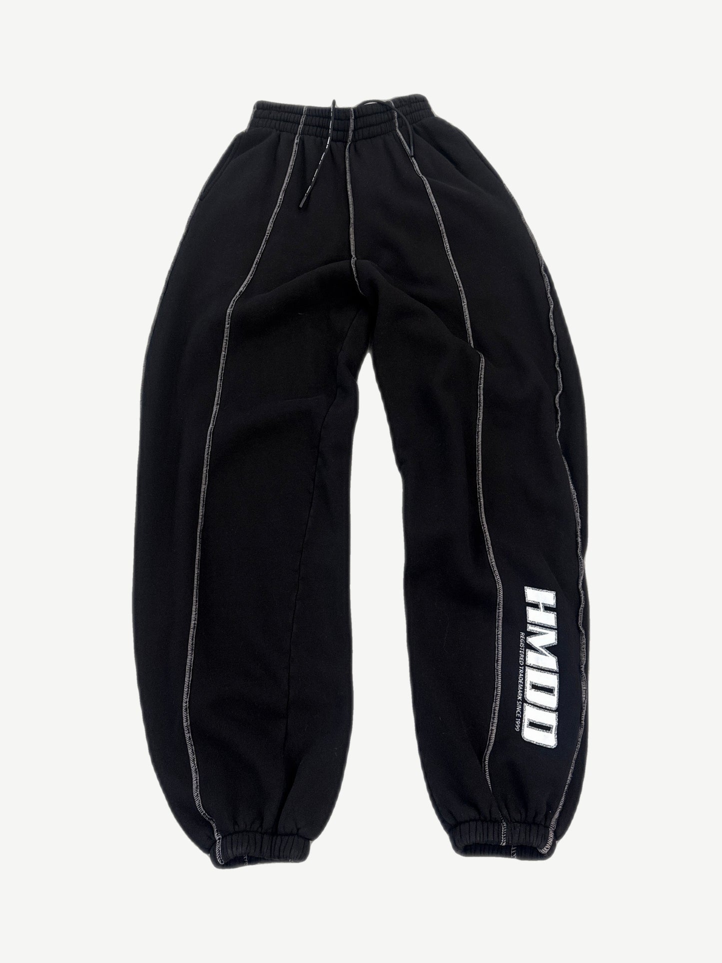 HMDD black baggy seam sweatpants front view with white contrast stitching and registered trademark leg print
