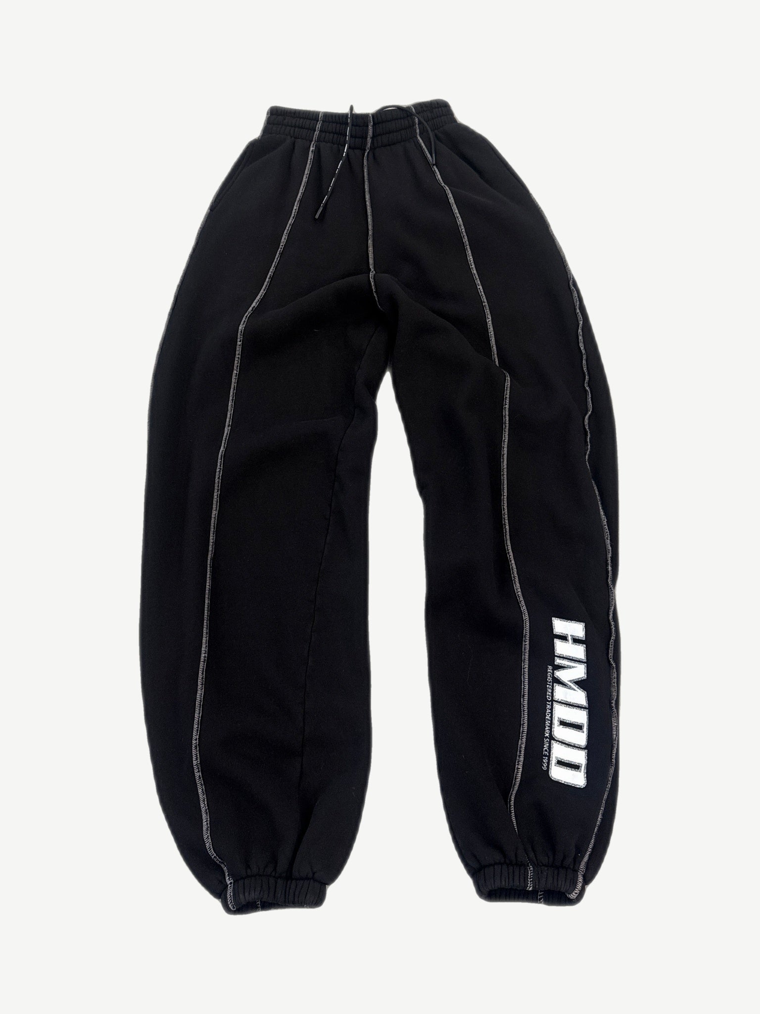 HMDD black baggy seam sweatpants front view with white contrast stitching and registered trademark leg print