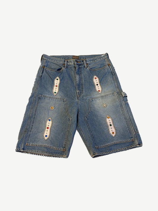Kapital light indigo denim carpenter shorts front with multicolor studded patches and tool pockets.