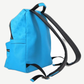 Side profile of Louis Vuitton blue Taigarama Discovery backpack showing monogram embossing and black leather straps